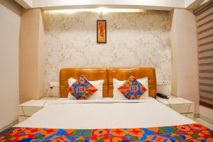 博帕尔FabHotel Divine Casa的一间卧室配有一张带棕色皮革床头板的床