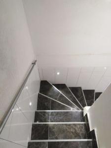 伯德古拉Apartment Anđela的铺有黑色大理石地板的楼梯和白色天花板