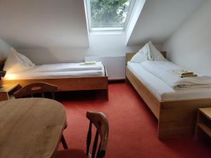 阿特尔高地区圣格奥尔根Pension Holzapfel的小房间设有两张床和一张桌子
