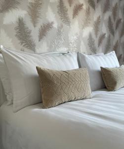 莱瑟姆-圣安妮Apartment 33 Lytham的白色的床、白色枕头和墙壁
