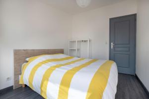 勒克鲁西克Escapade au Croisic!的卧室配有黄色和白色条纹床