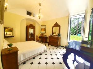 萨尔扎纳Villa De Benedetti的一间卧室配有一张床、一张书桌和一个窗户。