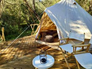 斯韦伦丹Gaia Double or Twin Bell Tent的木制甲板上的圆顶帐篷,配有桌椅