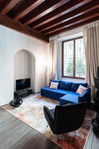 维罗纳Rosa Luxury Apartment的客厅设有蓝色的沙发和壁炉