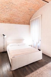 维罗纳Rosa Luxury Apartment的卧室设有一张白色大床和砖砌天花板。