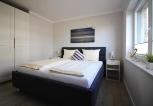格洛米茨Ostseeblick的一间卧室配有一张大床和蓝色床头板