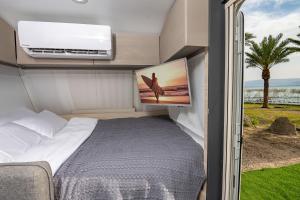 恩格夫Dream Caravan's - קרוואנים מושלמים למשפחות בחוף כורסי בכינרת的卧室位于走廊,设有床和窗户