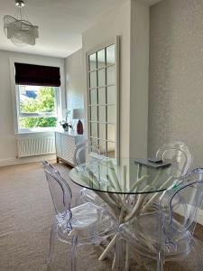 莱瑟姆-圣安妮Apartment 33 Lytham的一间设有玻璃桌和椅子的用餐室