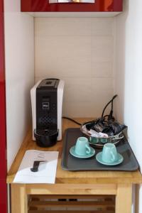 锡尔维玛丽娜B&B MELISSA的一张桌子,上面有打印机和两个杯子和碟子