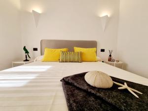 圣特奥多罗STAZZO SAN TEODORO IL GINEPRO的卧室配有一张带黄色枕头的大型白色床。