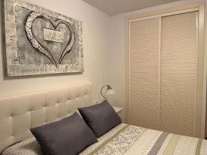 贝莱斯德韦瑙达利亚La Bicicleta, Duplex en Vélez Benaudalla的卧室配有一张壁挂着心画的床