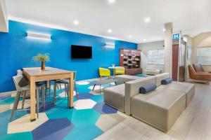 奥斯汀麦克罗迪尔温德姆韦汉姆奥斯丁机场酒店的蓝色的客厅配有沙发和桌子