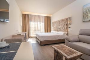 GelvesAljarafe Suites by QHotels的酒店客房,配有床和沙发