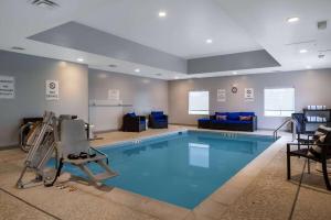 温彻斯特Microtel Inn & Suites by Wyndham Winchester的一个带椅子和沙发的房间的游泳池