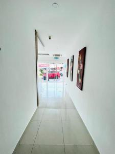 马六甲V Hotel Melaka (Near Jonker Street)的白色墙壁上挂有绘画的走廊