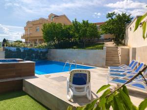 GnojniceLuxury Villa with Private Pool and Jacuzzi的后院设有游泳池和两把椅子