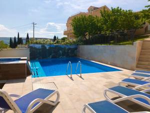 GnojniceLuxury Villa with Private Pool and Jacuzzi的一座房子旁带躺椅的游泳池