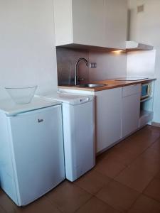 科斯塔德安提瓜FELIX HOUSE sea views的厨房配有白色橱柜、水槽和冰箱。