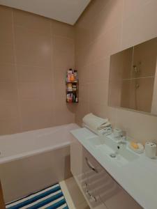 诺阿瑟Luxury résidence Taj Nouaceur的一间带水槽、浴缸和镜子的浴室
