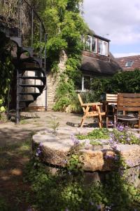 牛津Sandford Meadow Guest House的一个带木桌和长凳的花园