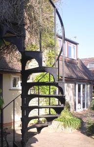 牛津Sandford Meadow Guest House的房屋前的螺旋楼梯