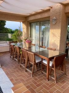 昂蒂布Panoramic sea view penthouse with jacuzzi and 450 sqm terrace的庭院里的餐桌和椅子