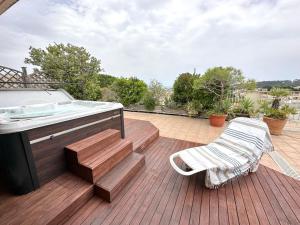 昂蒂布Panoramic sea view penthouse with jacuzzi and 450 sqm terrace的热水浴池和甲板上的长凳