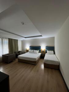 贝尔迪比Hotel Sumela Garden - All Inclusive的酒店客房,设有两张床和一张沙发