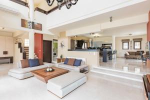 依克希亚Halide Luxury Villa的开放式客厅配有白色家具和厨房