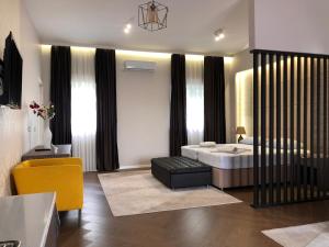 GnojniceLuxury Villa with Private Pool and Jacuzzi的一间卧室配有一张特大号床和一张黄色椅子