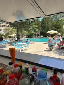 安吉Hotel Monte Mare - all inclusive的配有瓶子的桌子,享有游泳池的景致