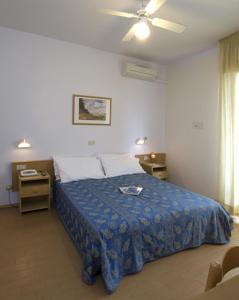 里乔内尼维斯酒店的一间卧室配有一张床和吊扇
