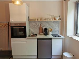 卡瓦永Studio confort - clim - ascenseur的厨房配有白色橱柜和水槽