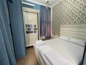 库塔伊西HOTEL AiSi აისი的卧室配有白色的床和蓝色的墙壁