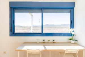 罗萨里奥港Roseville的一张蓝色的窗户,位于带桌椅的房间
