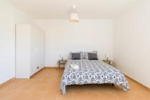 罗萨里奥港Roseville的一间卧室配有一张带蓝色和白色床单的床。