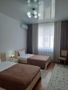 塔尔迪库尔干Апарт отель Welcome的一间卧室配有两张床和吊扇