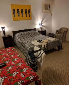 斯基灵角SAFARI Lodge Location Bungalow的一间卧室,卧室内配有一张床和一把椅子