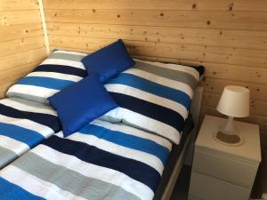 里沃Domki Wypoczynkowe "Sea Breeze"的一间卧室配有两张蓝色和白色条纹的床