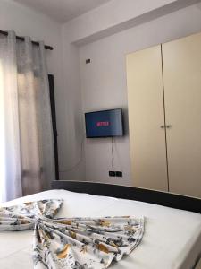 伏罗拉Villa Edi的一间卧室配有一张床,墙上配有电视