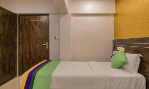 孟买Treebo Trend Atithi Inn的一间卧室配有一张带绿色枕头的床