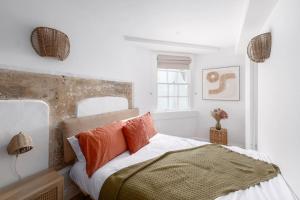 巴斯Newly Renovated City Apartment的白色卧室配有带橙色枕头的床