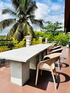 卡图纳耶克Otha Shy Airport Transit Hotel的一张大桌子,椅子和棕榈树