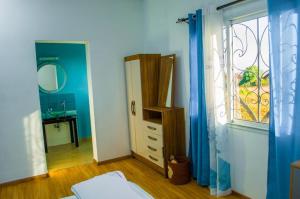 塔那那利佛Room in Villa - The blue room is an accent of modernity in the silence of the surrounding garden的一间卧室配有镜子、梳妆台和窗户