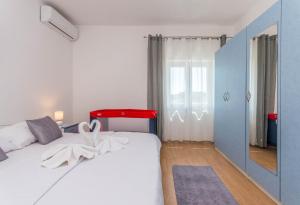 波拉卡Villa Branko的卧室配有白色的床和红色床头板
