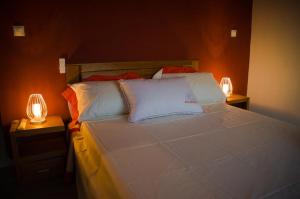 塔那那利佛Room in Villa - The romantic atmosphere of the red room to discover the pleasure of a stay的一间卧室配有一张大床和两盏灯