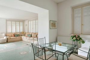 巴韦诺villa rosa的客厅配有玻璃桌和椅子