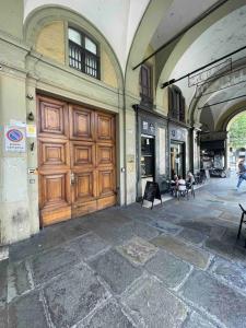 都灵Attico Porta Nuova, Torino Centro的大楼内有大木门,外面有人在