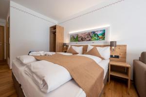 罗伊特Hotel Gasthof Klause Dependance 2的一间卧室配有一张带白色床单的大床