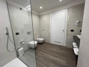 夏卡RoccaRegina Hotel的一间带卫生间和玻璃淋浴间的浴室